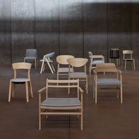 "Collection of wooden chairs in natural tones and gray upholstery, featuring various sleek designs and patterns."