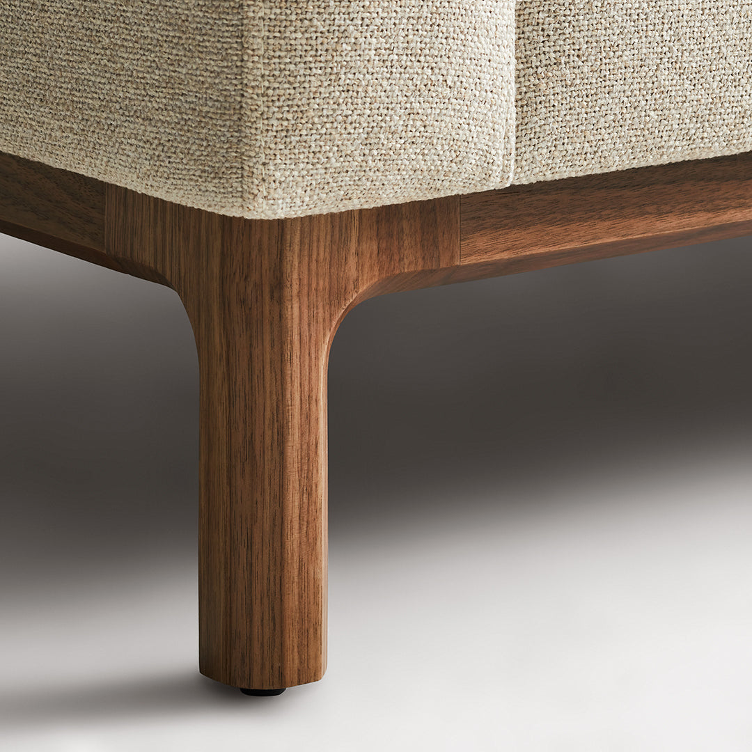 Beige textured upholstery with a warm wood finish on the legs, showcasing a modern, minimalist design.