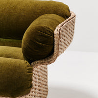 Olive green velvet cushion with woven natural fiber base, featuring a textured pattern for a modern, chic look.