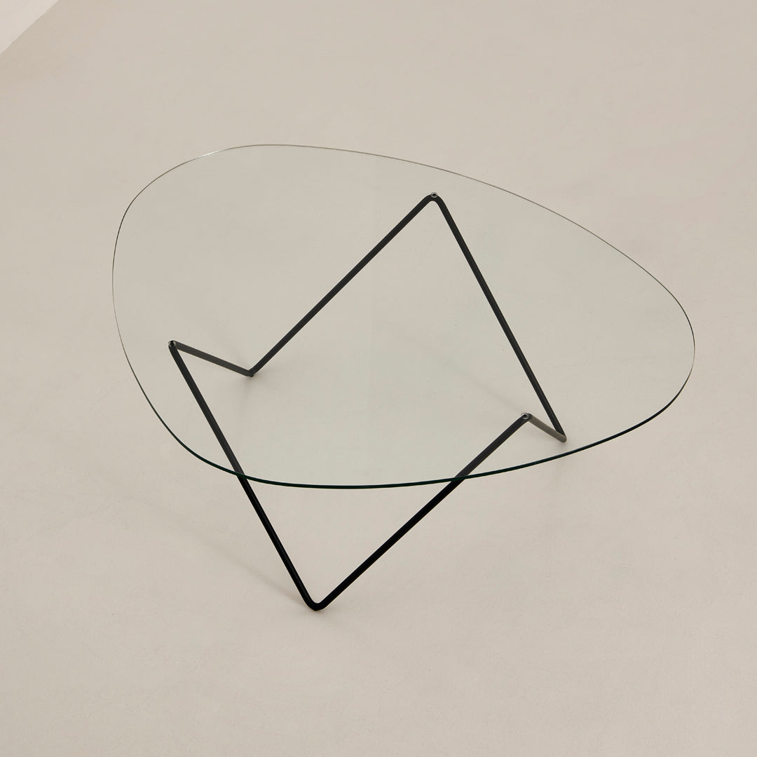 Modern glass coffee table with an irregular oval top and sleek black metal frame. Perfect for minimalist decor.