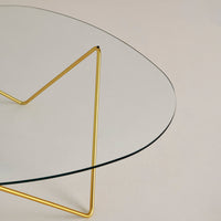 Stylish clear glass tabletop with a gold geometric base, featuring a sleek, modern design. Perfect for contemporary spaces.