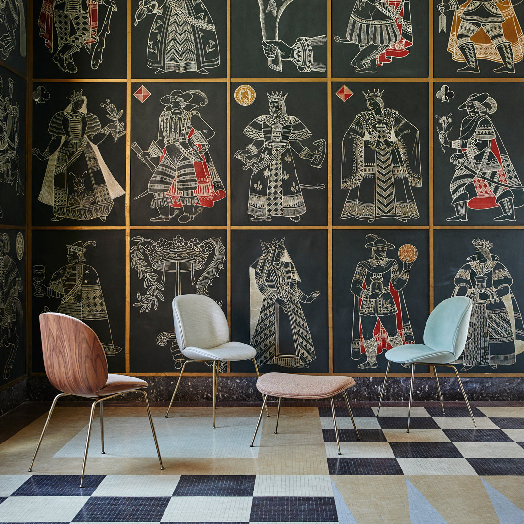 "Stylish chairs in soft pastels on a contrasting black and cream patterned floor with vibrant wall art."