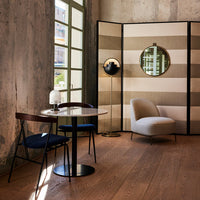 Contemporary room featuring soft beige and white striped screen, dark wood accents, and muted blue elements.