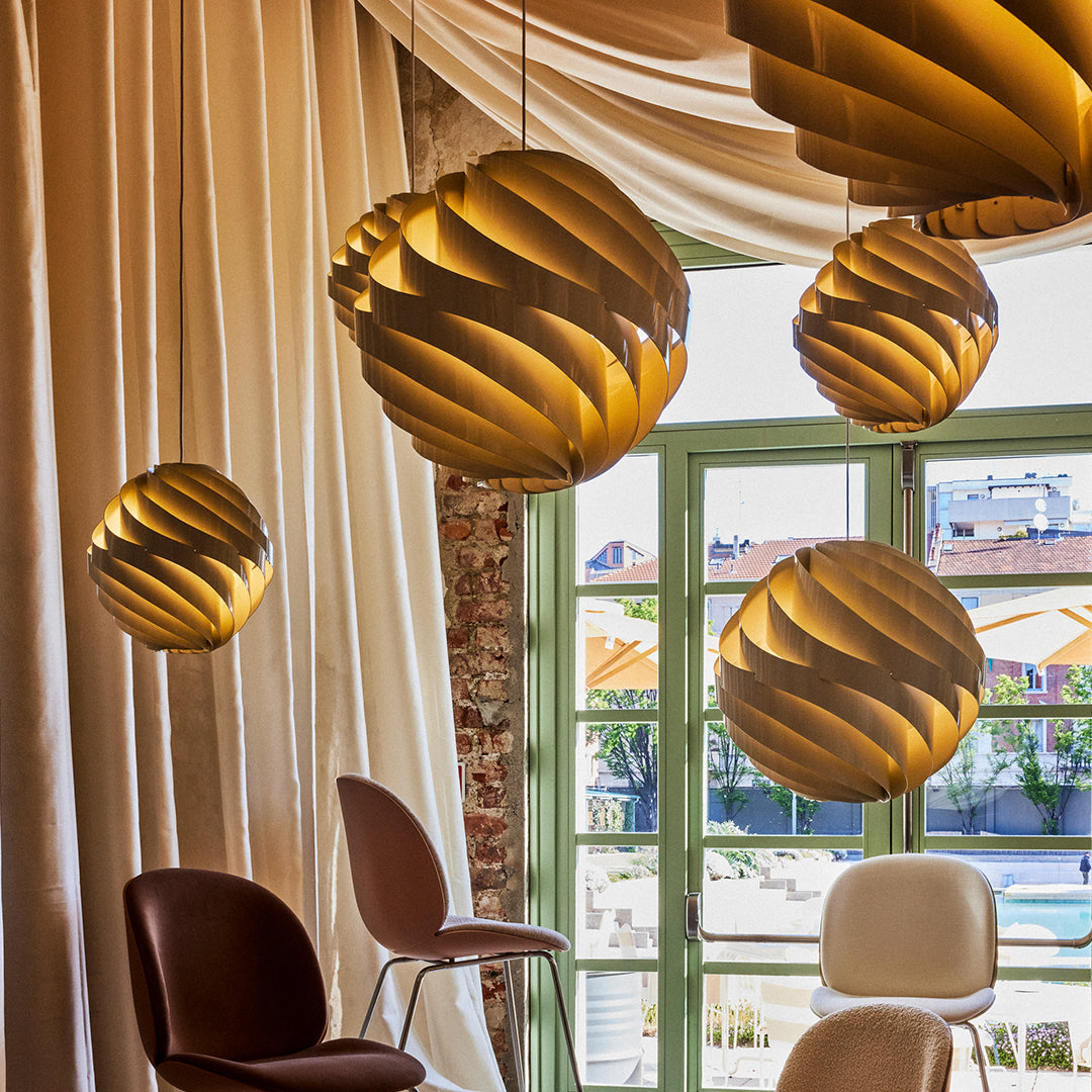 "Modern pendant lights in warm amber tones with swirling patterns, enhancing contemporary decor."