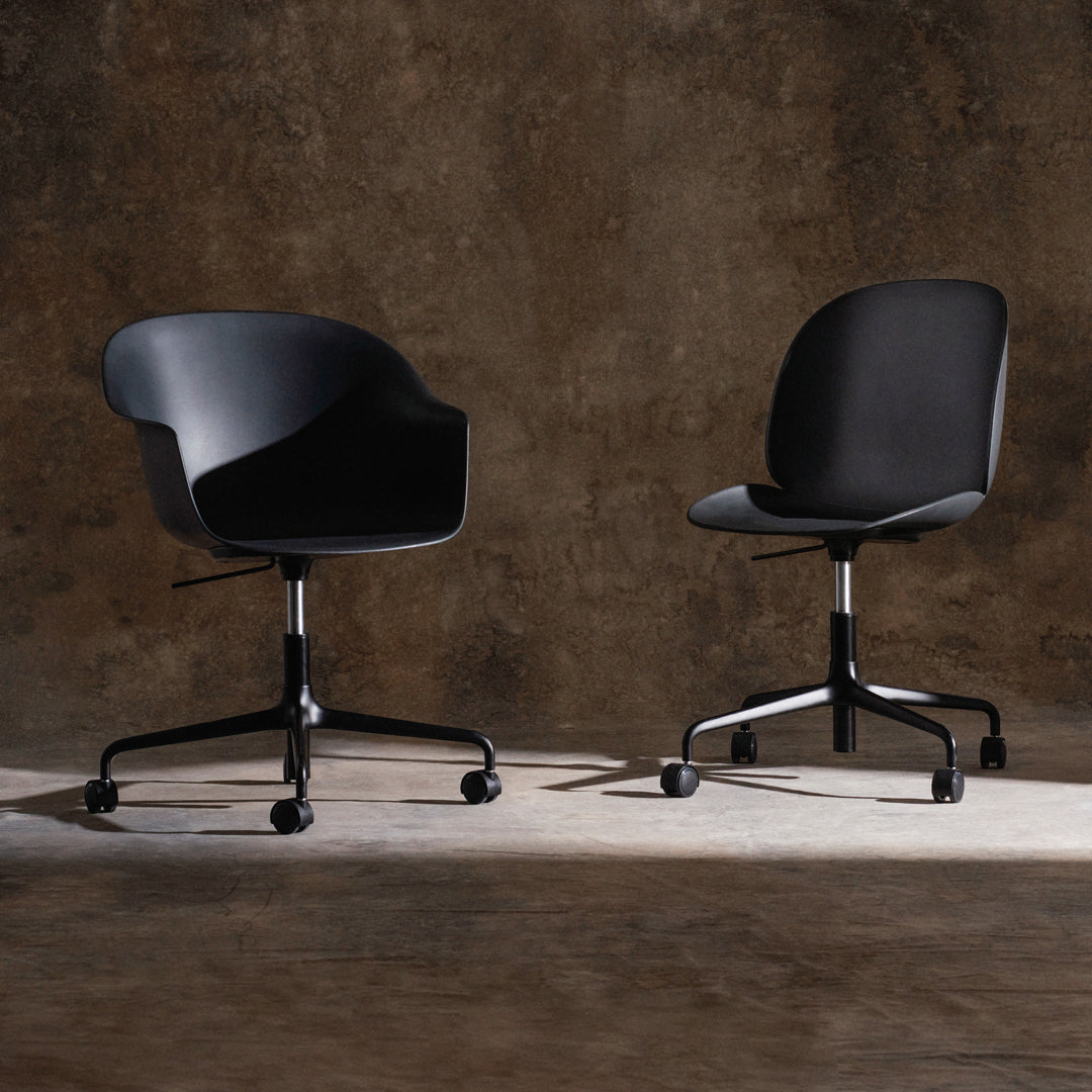 Black ergonomic office chairs on a textured brown background, showcasing smooth curves and sleek design.
