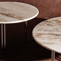 Round marble tables with elegant beige and gray patterns, complemented by sleek metallic legs on a rich brown background.