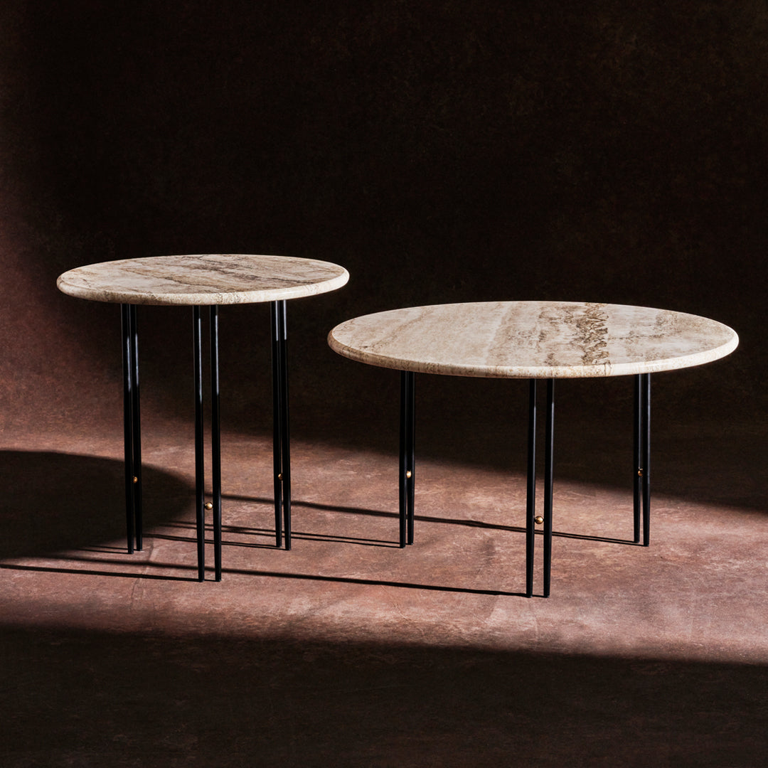 Round marble tables with earthy tones and subtle veining, complemented by sleek black metal legs.