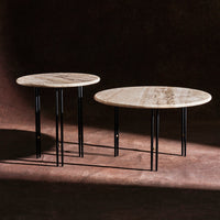 Round marble tables with earthy tones and subtle veining, complemented by sleek black metal legs.