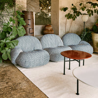 Blue patterned bean bag chairs with a textured design, surrounded by greenery and modern tables in a stylish setting.