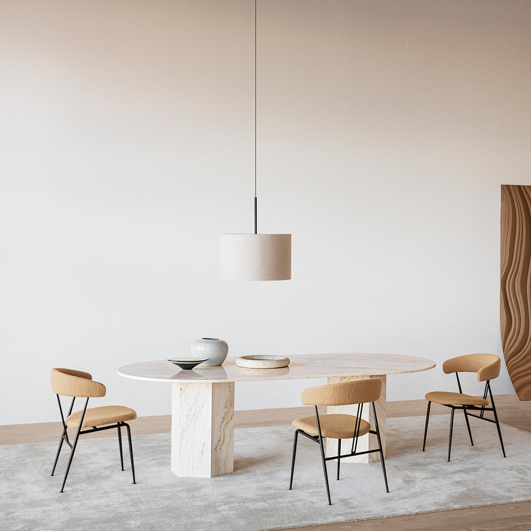 Minimalist dining table with a white marble top and natural wood chairs on a soft gray rug. Elegant neutral color palette.