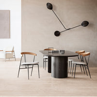 Modern dining table with sleek black finish, complemented by light wooden chairs and neutral-toned walls.
