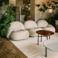 Neutral beige bubble chair trio with textured fabric, complemented by a sleek black table in a green, natural setting.