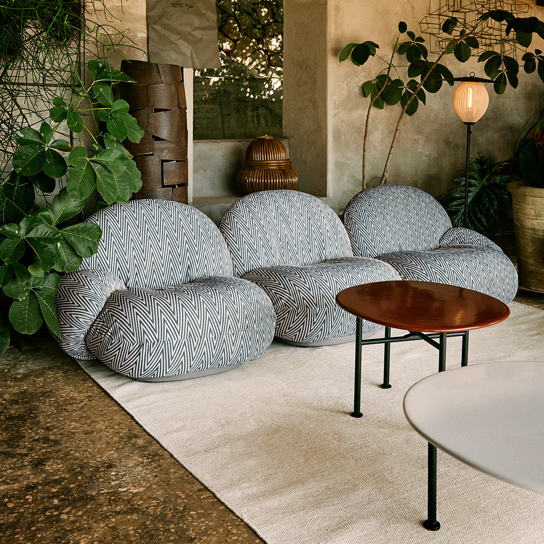 "Light gray bean bag chairs with subtle textured patterns in a cozy, green indoor setting."