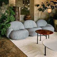 "Light gray bean bag chairs with subtle textured patterns in a cozy, green indoor setting."