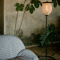 Textured blue and white zigzag patterned upholstery on a cozy sofa, complemented by a soft beige lamp shade.