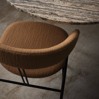 Brown textured upholstery chair with black metal legs, paired with a patterned marble tabletop. Elegant and modern design.