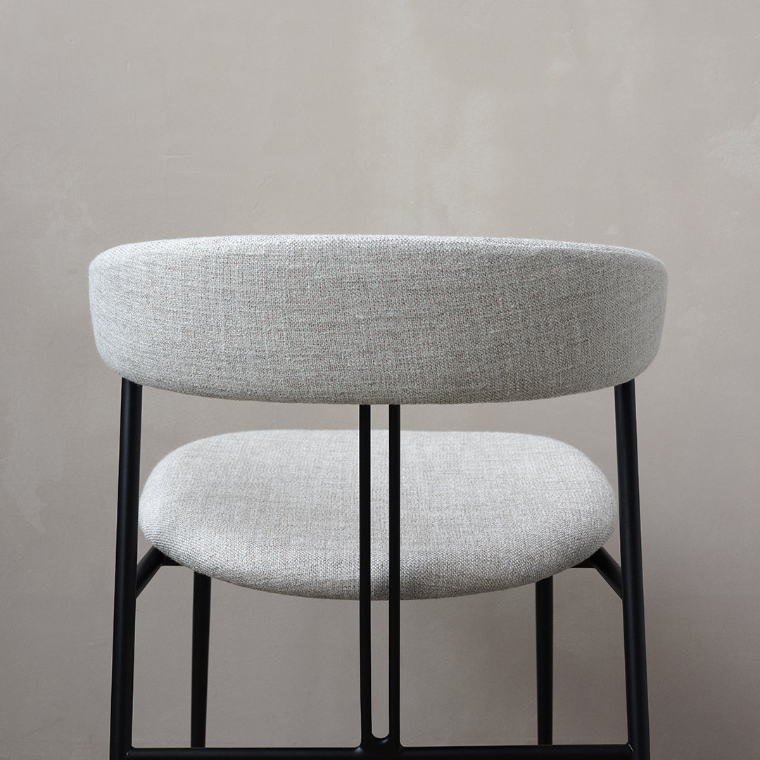 Gray upholstered chair with a sleek black metal frame, featuring a minimalist design and subtle texture.
