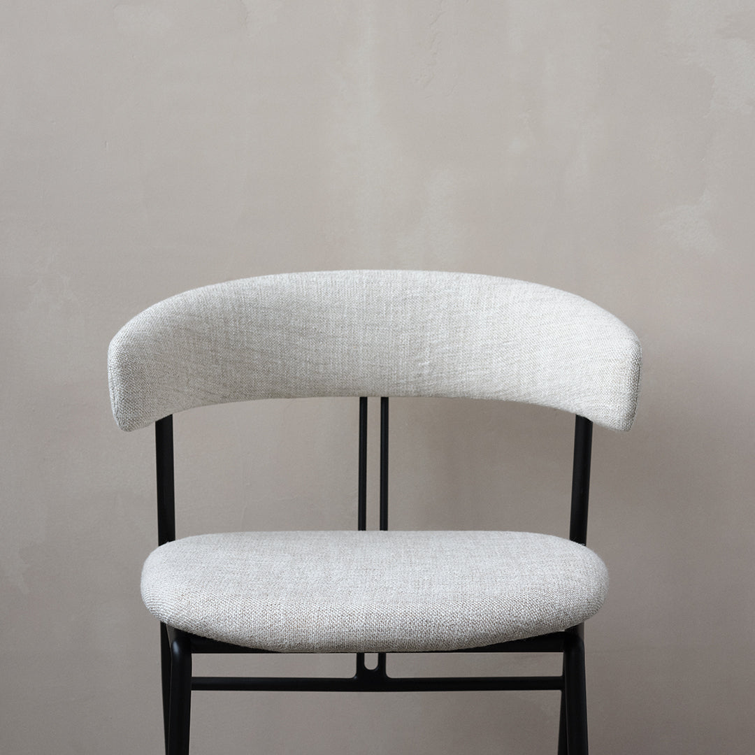 Light gray upholstered chair with a textured fabric seat and backrest, contrasted by a sleek black metal frame.