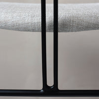 Light gray linen seat with a textured pattern and sleek black metal frame. Stylish and modern design details.