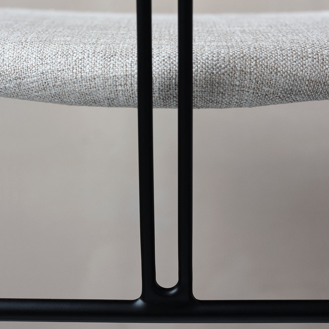 Neutral linen seat in light gray with sleek black metal frame, showcasing minimalist design and texture.