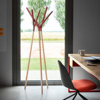 Wooden coat rack with a natural finish and vibrant red hooks, set against a modern indoor backdrop.