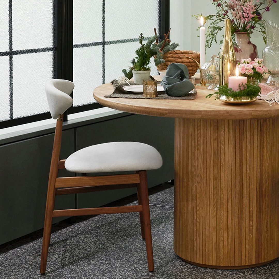 Modern wooden dining table with beige upholstered chair, featuring natural textures and soft tones, perfect for elegant settings.