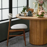 Modern wooden dining table with beige upholstered chair, featuring natural textures and soft tones, perfect for elegant settings.
