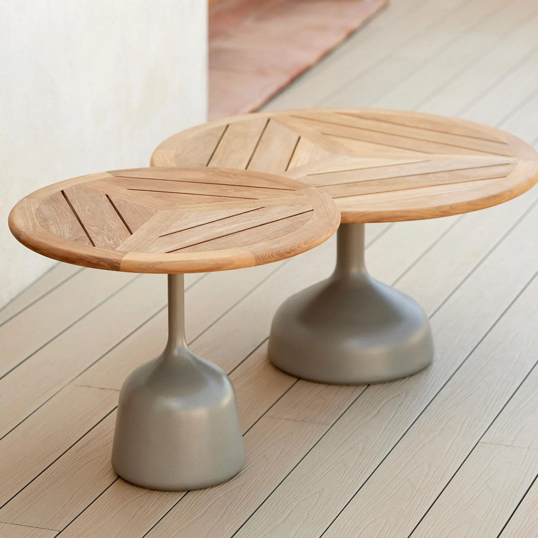 Wooden round coffee tables with geometric patterns and gray bases, showcasing natural and modern aesthetics.