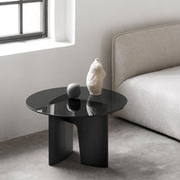 Modern black round coffee table with a glossy surface and minimalistic design, set against a neutral backdrop.