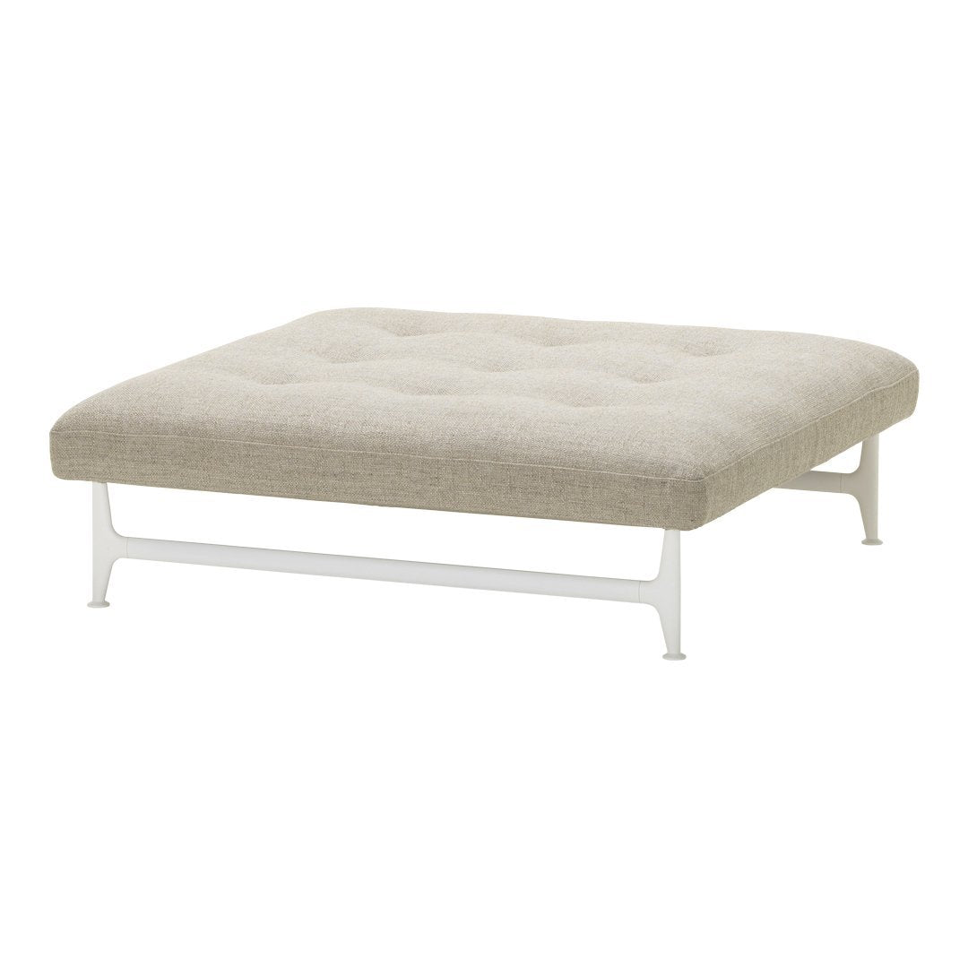 Beige tufted ottoman with a minimalist white metal frame, perfect for modern decor.