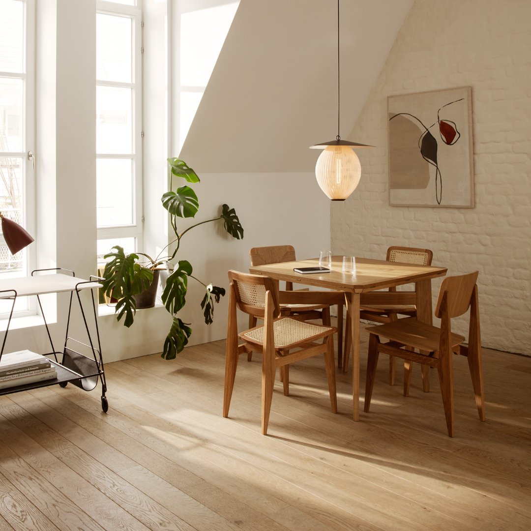 Light wood dining set with a natural finish, accompanied by greenery and soft, neutral-toned decor.