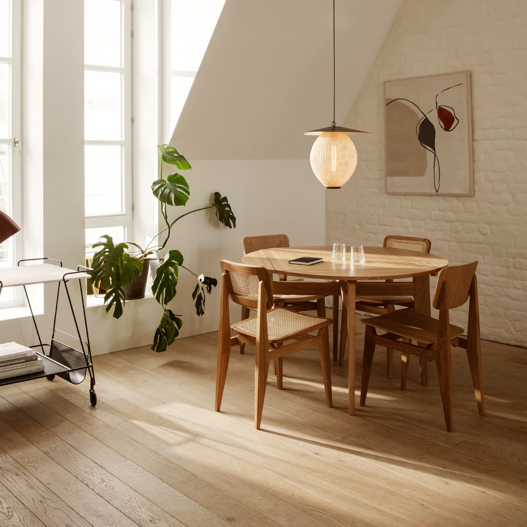Light wood dining table and chairs with a warm, natural finish; minimalistic design complements neutral tones and soft lighting.