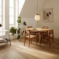 Light wood dining table and chairs with a warm, natural finish; minimalistic design complements neutral tones and soft lighting.