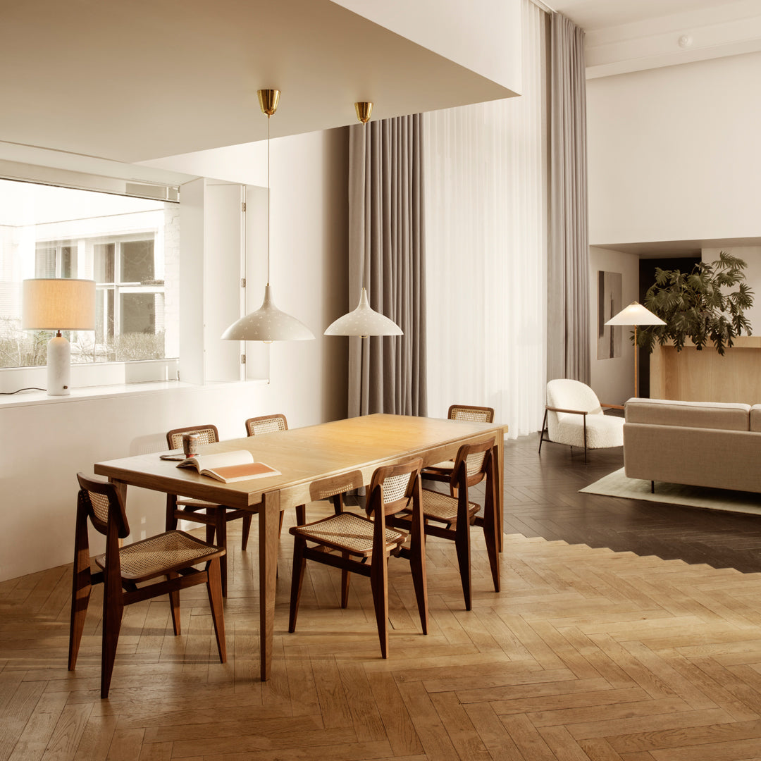 "Modern dining room with light wood table, dark wooden chairs, neutral curtains, and soft beige accents."