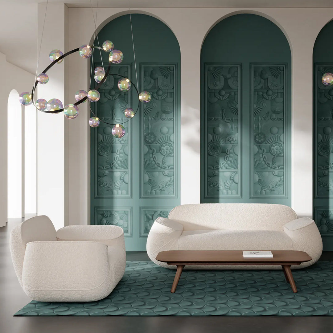 Elegant white sofa and armchair on teal patterned rug with decorative multi-colored bubble light fixture.