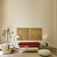 Modern living room featuring a brick-red sofa, soft pastel blue chair, neutral-toned walls, and earthy decor accents.