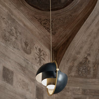 Sleek black and white pendant light with gold accents, featuring an elegant curved design. Perfect for modern interiors.