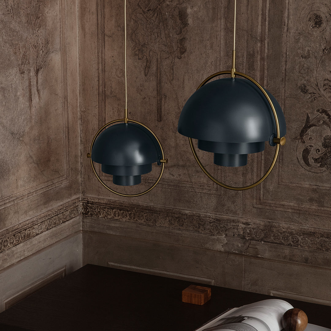 "Dark blue pendant lights with sleek gold accents against a vintage wall design."