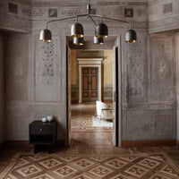 Stylish gray walls with intricate patterns, warm brown wooden floor, and modern black and gold light fixtures.