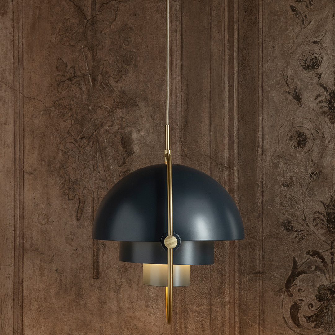 Modern black and gold pendant lamp with a sleek, curved design and layered shades against a textured brown background.