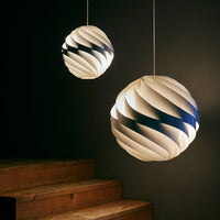 Two hanging pendant lamps featuring a spiraled white and blue pattern, illuminated against a dark background.