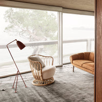Cozy interior featuring a beige rocking chair, brown sofa, and warm wood accents against a neutral gray carpet.