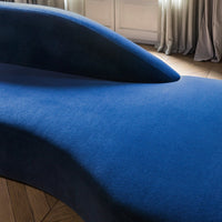Sleek, modern blue lounge chair with a smooth texture and distinctive curved design. Ideal for contemporary interiors.