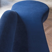 Curved navy blue velvet chaise lounge with a smooth, modern design and a soft texture. Perfect for stylish interiors.