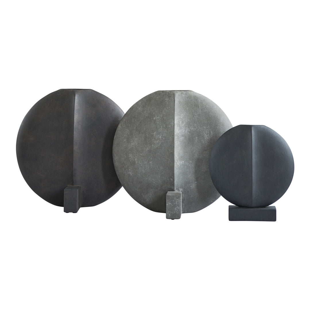Set of three circular decorative objects in shades of gray, featuring smooth and textured surfaces with minimalist design.