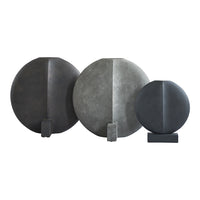 Set of three circular decorative objects in shades of gray, featuring smooth and textured surfaces with minimalist design.