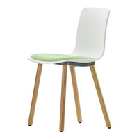 White modern chair with green seat cushion and natural wood legs. Minimalist design for a contemporary look.