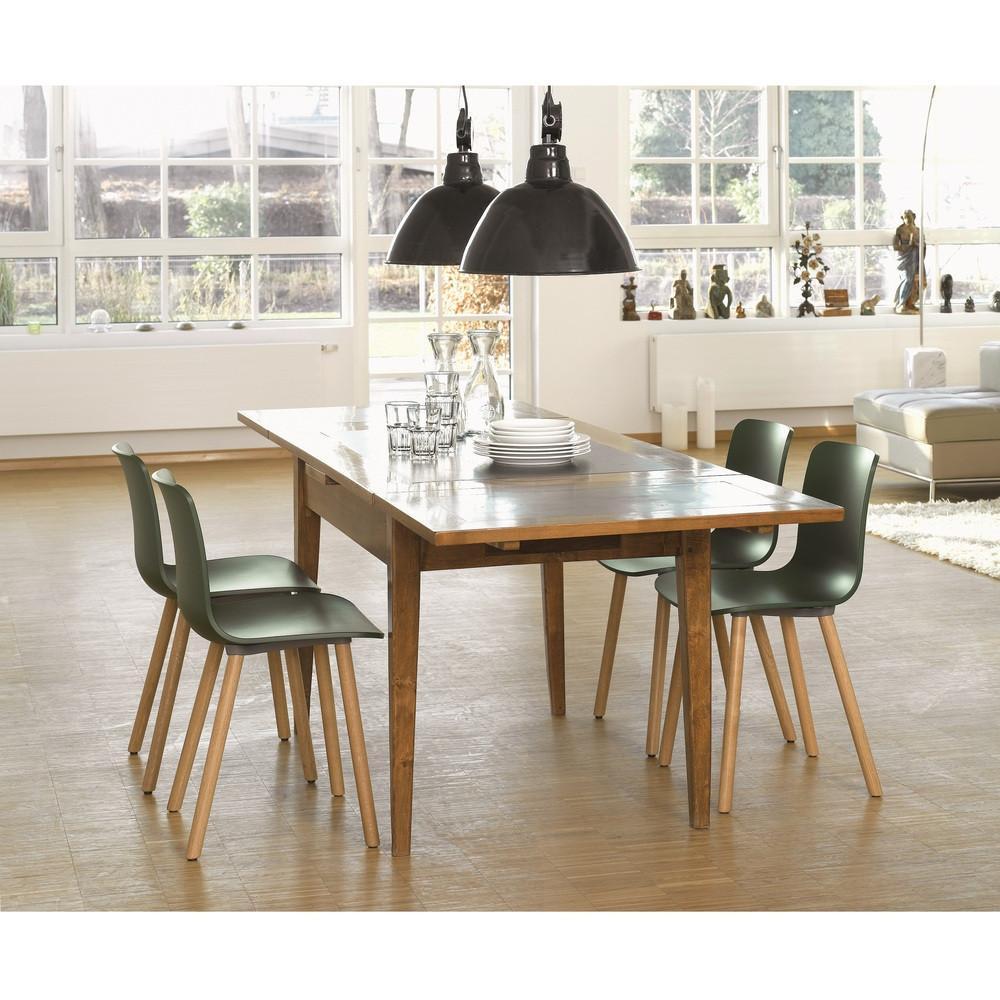 Modern wooden dining table with slate top and green chairs, complemented by black pendant lights and a light wooden floor.