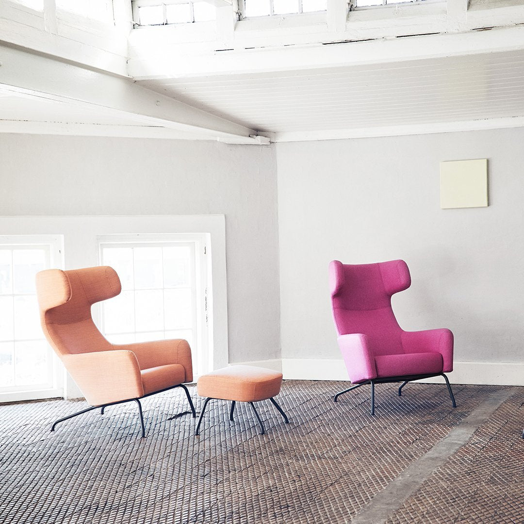 "Modern chairs in soft pink and coral hues with unique curved designs, perfect for contemporary decor."