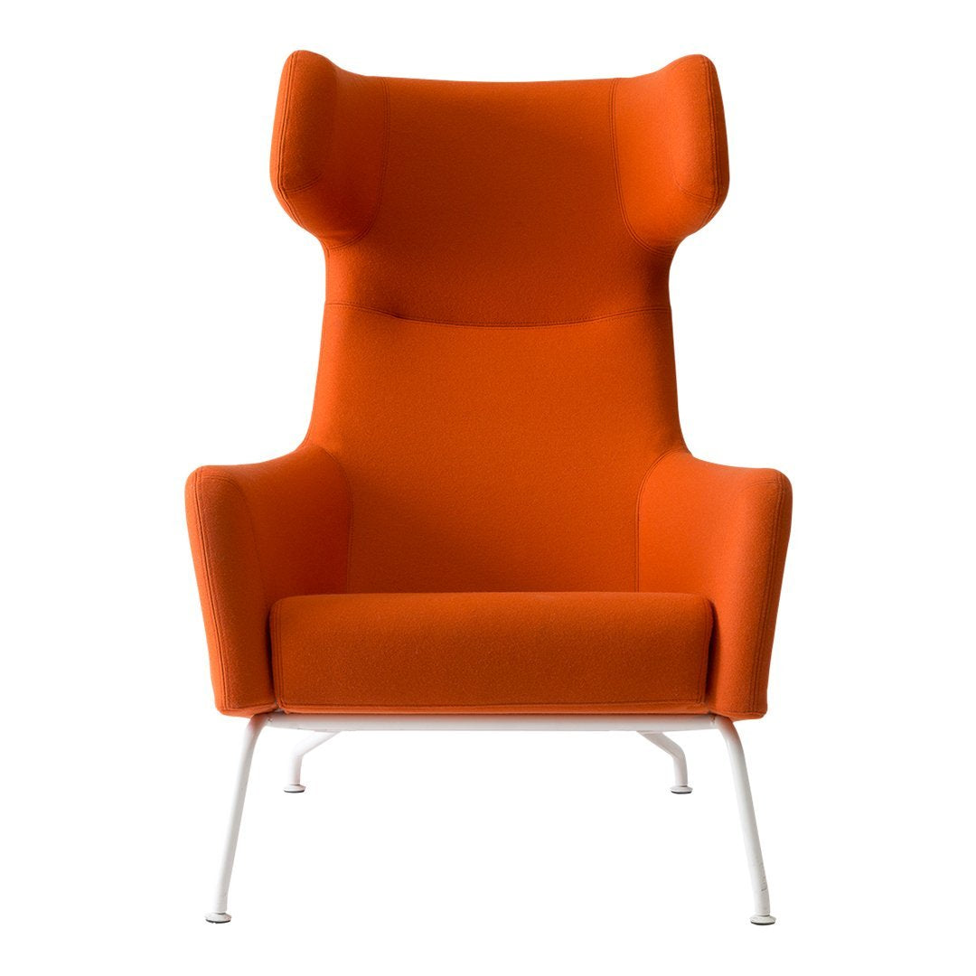 Bright orange upholstered chair with a unique high-back design and sleek white legs. Ideal for modern decor.